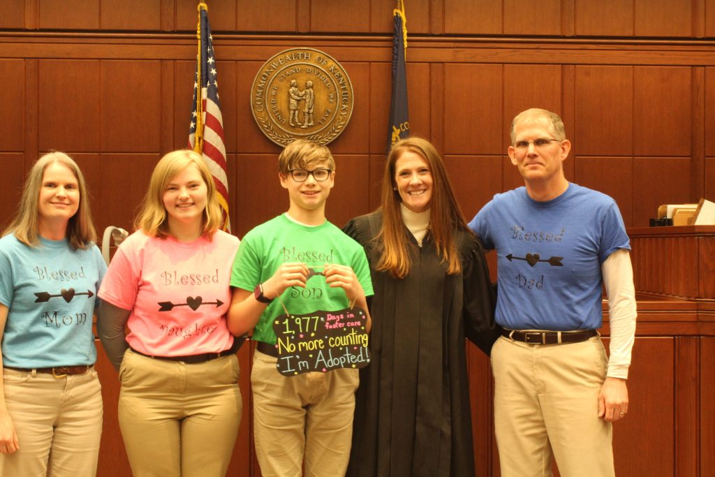 The Hurt-Mueller family with a judge following the adoption of their son, Will.