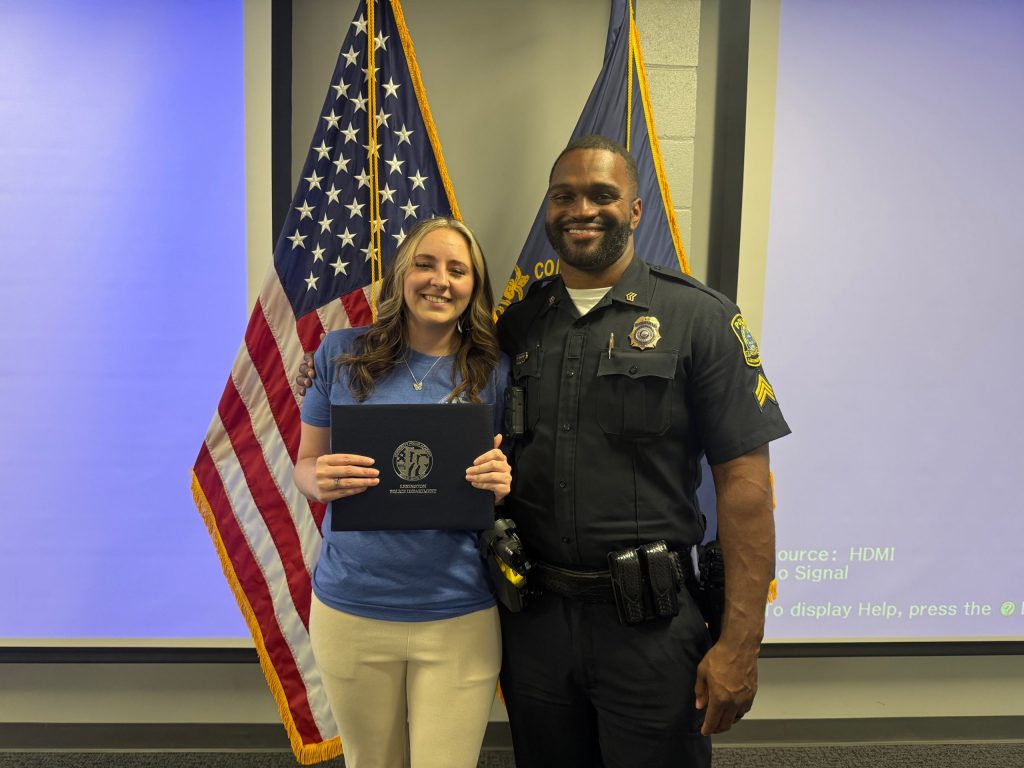 Tiffany Malicote holding diploma with Sergeant Donald Horton at the Lexington Community Police Academy