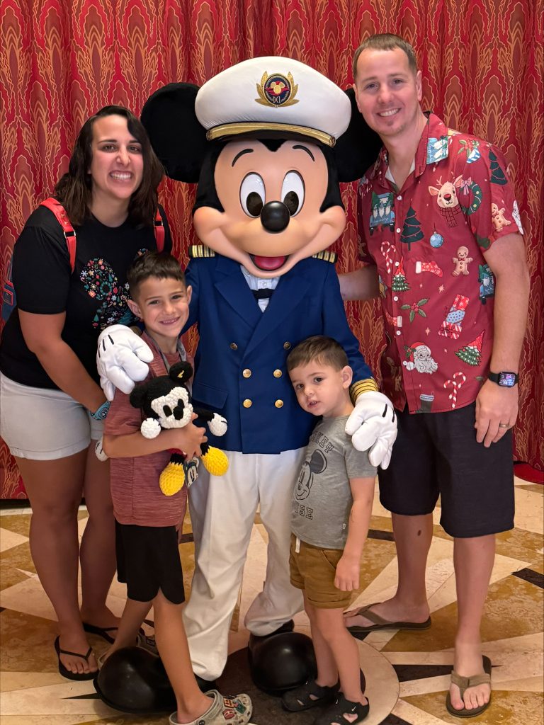 The Johnson family posing with Mickey Mouse at Disney World