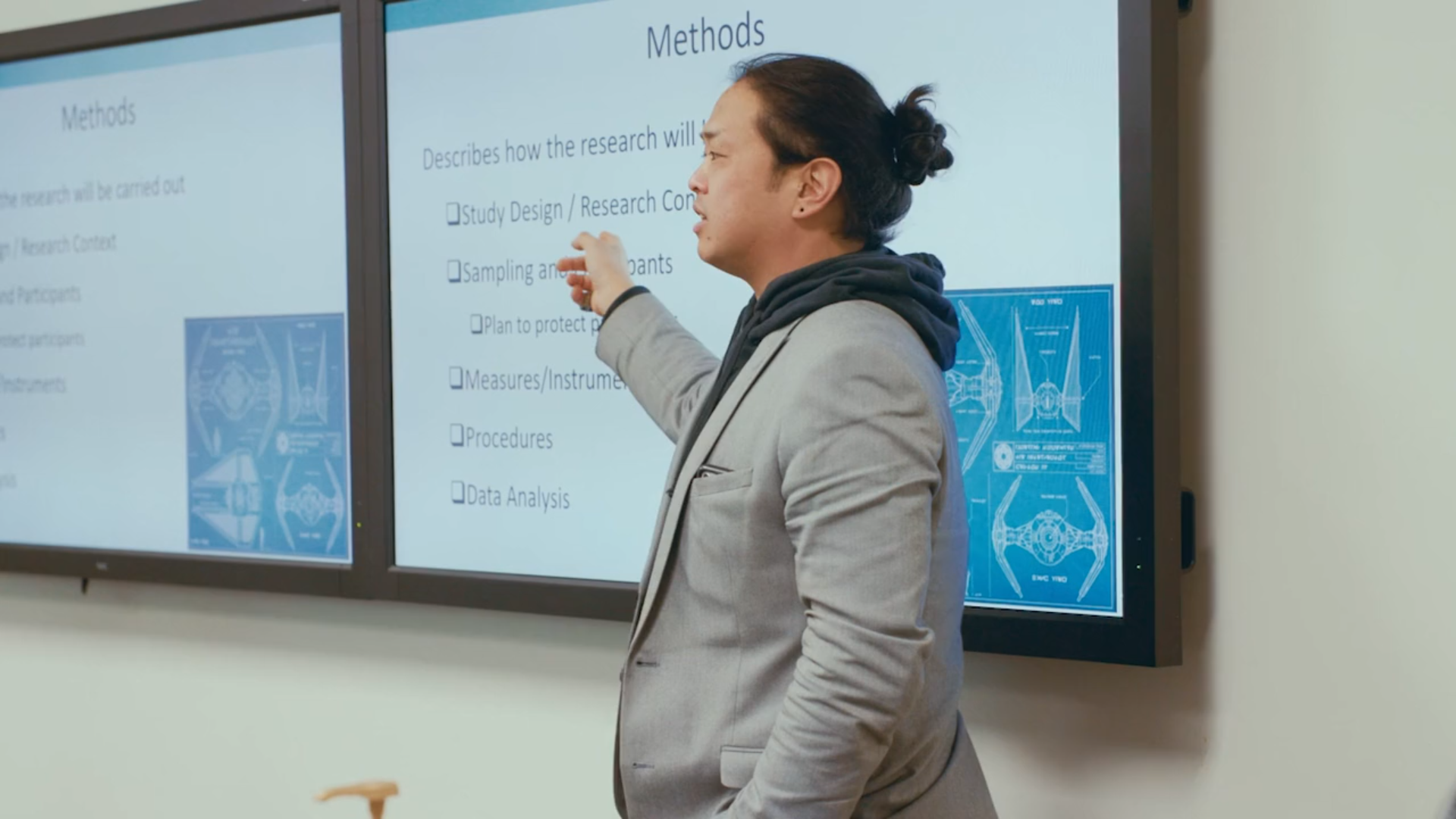 Dr. Tarkington Newman pointing at a presentation while teaching